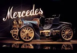 Automóvil Mercedes de principios del siglo XX iluminado bajo el rótulo «Mercedes» en un museo