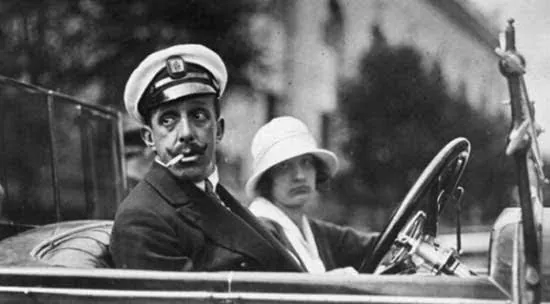 King Alfonso XIII at the wheel of an open car, wearing a peaked cap, beside a lady, early 20th century